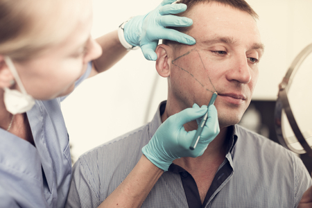 Female doctor is preparing patient for procedure with using marker in estetic clinic.の写真素材