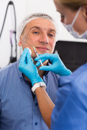 Female specialist is doing injection to client for anti-aging in estetic clinic.の写真素材