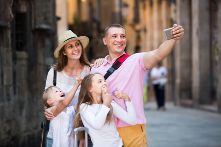 Happy spanish family of tourists making selfie during travelling on European cityの写真素材