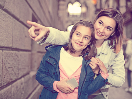 Young mother giving explanations to daughter during sightseeing tour. Focus on both personsの写真素材