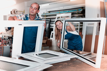 Portrait brigade of two people working at workshop for production of plastic windows