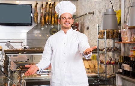 Handsome ordinary male seller working at meat marketの写真素材