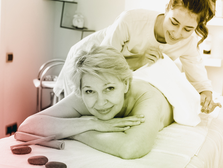 Mature woman client having massage procedure in beauty salonの写真素材