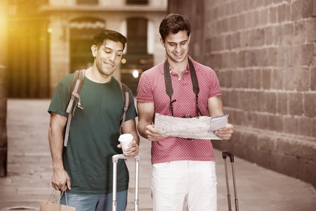 cheerful men are walking and searching way to historical sight in map in Barcelona outdoorsの写真素材
