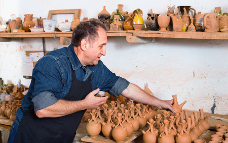 Happy smiling positive glad potter at the workshopの写真素材