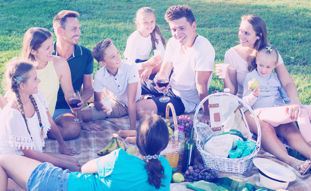 Two friendly families with kids gaily spending time together at picnic in natureの写真素材
