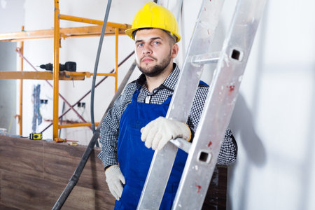 Portrait of smiling workman which is plastering the place.