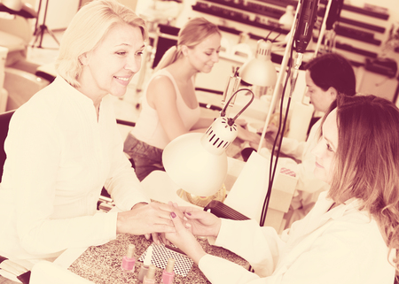 Two ordinary clients doing manicure in nail salonの写真素材