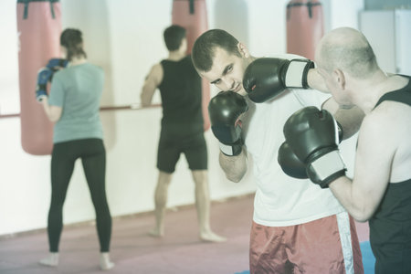 Portrait of active sportsmen competing in boxing gloves