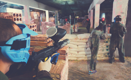 Players are sighting in opponents from barricades on paintball fieldの写真素材