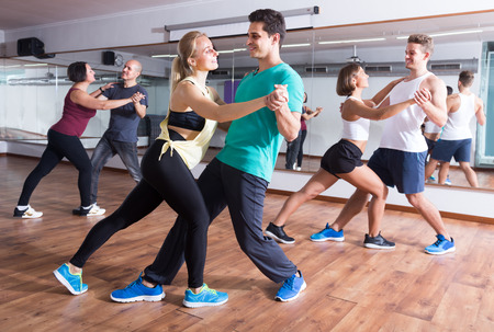 Young sporty girls and men dancing salsa stepsの写真素材