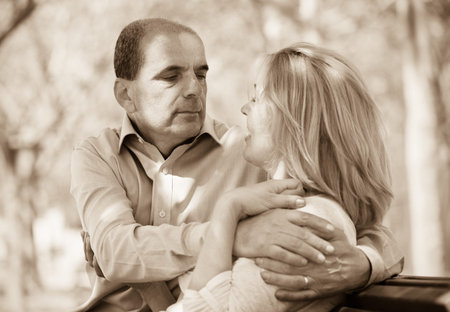 Happy senior lovers hugging each other in summer park