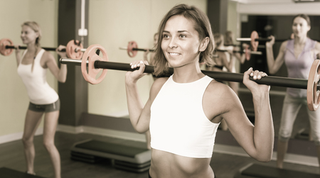 happy swedish athletic girls during workout in gym with barbellの写真素材