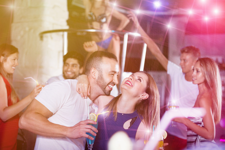 Happy cheerful  smiling man and woman dancing and hugging on party in the clubの写真素材