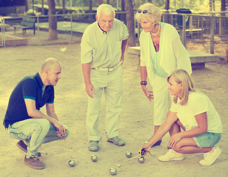 Happy family of two generations playing bocce at a gardenの写真素材