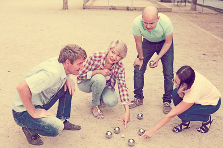 Portrait of friendly mature couples playing petanque at leisureの写真素材