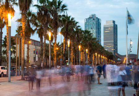 Illuminated quay next to Barceloneta beach in Barcelona with blurred peopleのeditorial素材