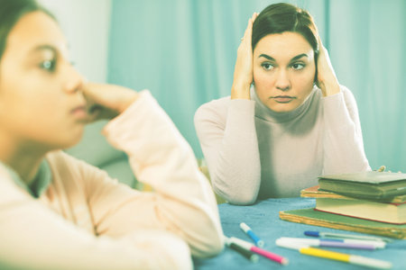 Mother talking seriously with her teenage daughter about poor school performance