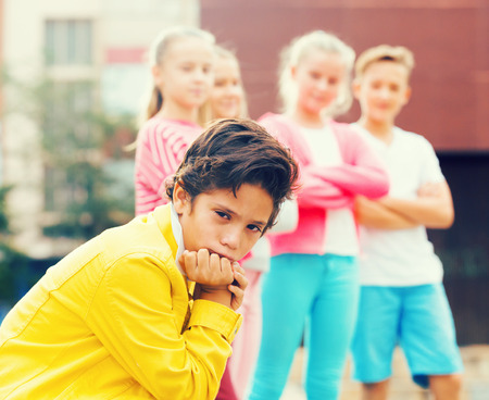 Portrait of boy 9-12 years old who is taking offense on his friends in the park.の写真素材
