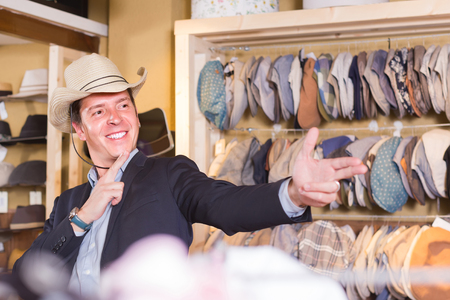 happy russian adult male try on western hat at the shopping centerの写真素材
