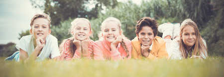 Portrait of kids company who are walking and posing in the park.の写真素材