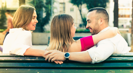 Image of the love triangle between young smiling cheerful positive people outdoorの写真素材