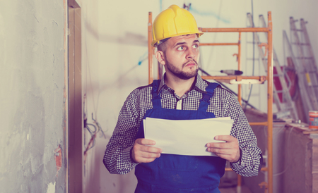 Serious  builder is looking on the project of work for the object.の写真素材