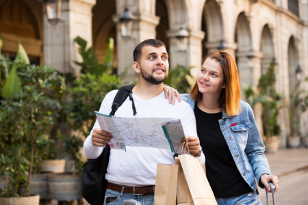 Portrait of tourists with package walking with map at streetの写真素材