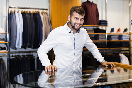 Portrait of smiling young man seller in men's boutiqueの写真素材