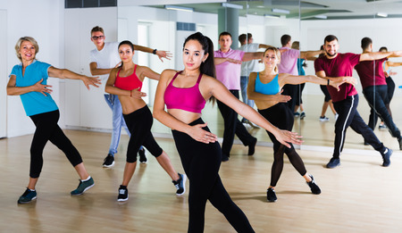 friendly men women of different ages posing in fitness studioの写真素材