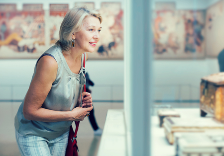 Adult female looking at artwork copper exhibit in the gallery indoorsの写真素材