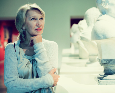 Portrait of woman visitor near sculpture in the historical museumの写真素材