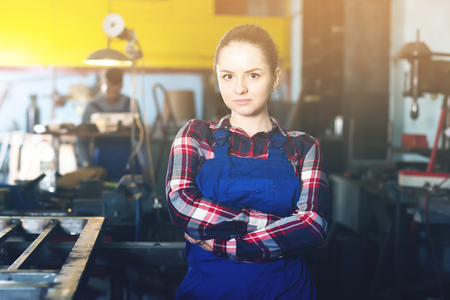 Young female who is standing on her workplace in workshopの写真素材