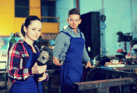Young woman is working with circular saw on her workplace in workshop.の写真素材