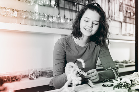 Young girl seller offering colored necklaces and pendants in the storeの写真素材