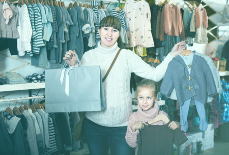 Positive pregnant woman and child enjoying purchases in childrenâs cloths store
の写真素材