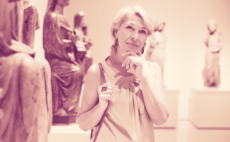 Portrait of visitor female near sculpture in the historical museum の写真素材