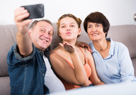 Happy family is taking selfie on the phone at home.の写真素材