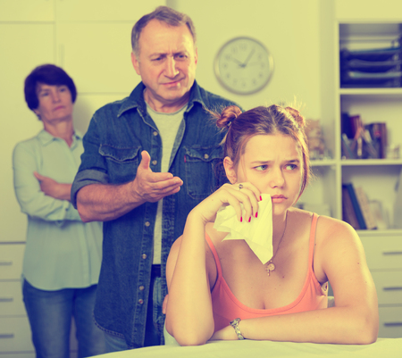 Father is comforting the upset adult daughter at home.の写真素材