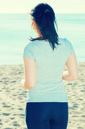 Energetic girl running on beach on sunny dayの写真素材