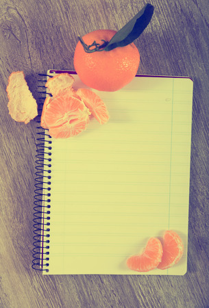 Notebook in range surrounded by fruitの写真素材