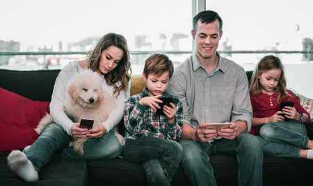 Young happy family playing with their smartphones together at home