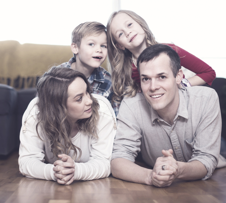Smiling family enjoying quiet evening together at homeの写真素材