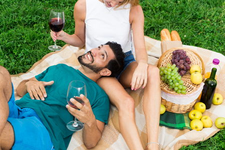 Man is lying on the lap of girlfriend in time picnic in the park.の写真素材