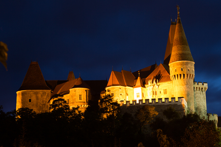 Impressive night landscape with illuminated medieval Corvin Castle on elevated rock, Hunedoara, Romaniaのeditorial素材