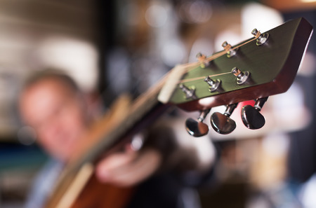 Image of acoustic guitar close-up in time playing on it in music storeの写真素材