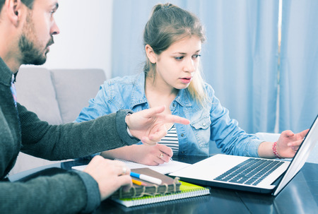 Young germany positive tutor explaining material to his female client at home
の写真素材