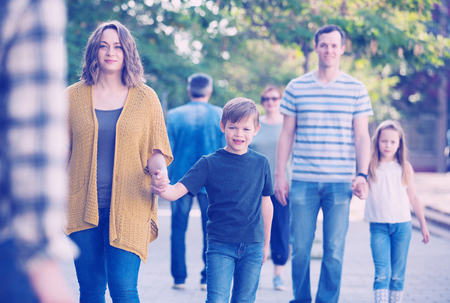 Smiling family of different ages walk in the park on holidayの写真素材