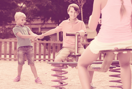 Positive british children are teetering on the swing in the playground.
の写真素材