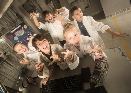 Group of children are concentrating on finding a way out of bunker quest roomの写真素材